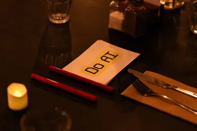 Do AI place card on a dinner table with cutlery and candle